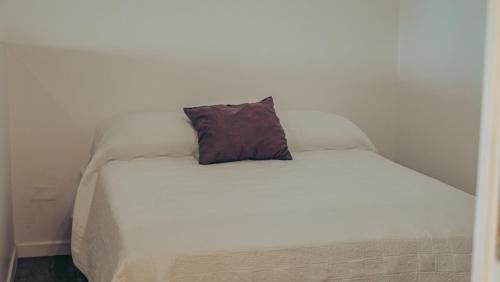 a white bed with a pillow on top of it at Pension Irivai, Appartement RAVA 1 chambre bord de mer in Uturoa
