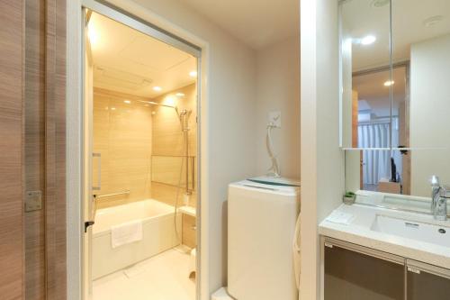 a bathroom with a shower and a toilet and a sink at HIZ HOTEL Ginza in Tokyo