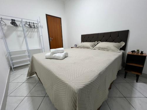 a bed with two towels on it in a bedroom at Apartamento Central in Ipatinga