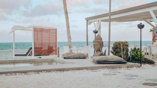 a resort with a statue on the beach at Pension Irivai, Appartement RAVA 1 chambre bord de mer in Uturoa