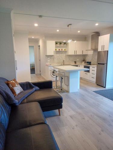 a kitchen and living room with a couch and a table at The Guest House in Tamahere