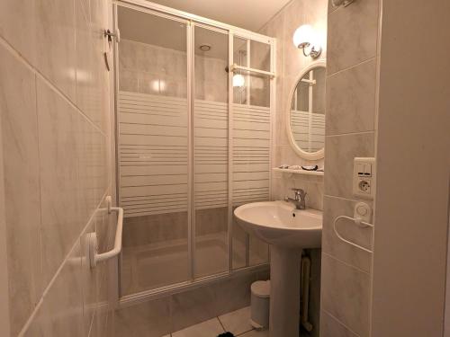 une salle de bain blanche avec une douche et un lavabo dans l'établissement Bel appartement T3 au centre d'Arcachon avec parking - FR-1-420-152, à Arcachon