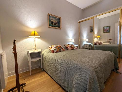 une chambre avec un lit et un grand miroir dans l'établissement Bel appartement T3 au centre d'Arcachon avec parking - FR-1-420-152, à Arcachon