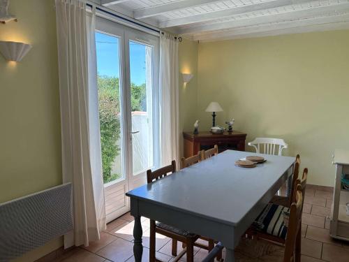une salle à manger avec une table et une grande fenêtre dans l'établissement Maison indépendante 6 pers. avec terrasse, barbecue et parking, à 6 km de la plage - FR-1-224A-67, à LʼAiguillon-sur-Vie