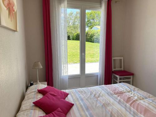 une chambre avec un lit avec des oreillers rouges et une fenêtre dans l'établissement Maison indépendante 6 pers. avec terrasse, barbecue et parking, à 6 km de la plage - FR-1-224A-67, à LʼAiguillon-sur-Vie