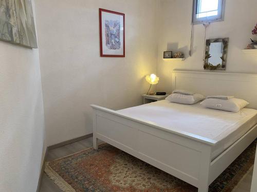 une chambre avec un lit blanc dans une pièce dans l'établissement Duplex à 30m de la plage avec parking privé - FR-1-782-63, au Barcarès