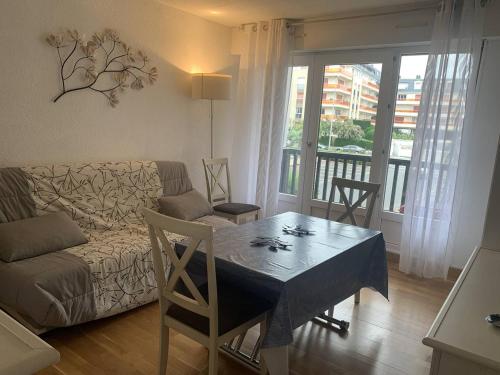 un salon avec un canapé et une table dans l'établissement Appartement lumineux à 50m de la plage de Cabourg, balcon, parking gratuit, 4 pers. - FR-1-465-119, à Cabourg