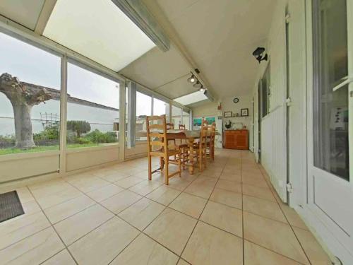 une salle à manger avec une table, des chaises et des fenêtres dans l'établissement Maison Oléron 6 pers - Plage et Piste Cyclable à Proximité, Jardin Clos, Ménage Inclus - FR-1-246A-309, à Saint-Denis-dʼOléron