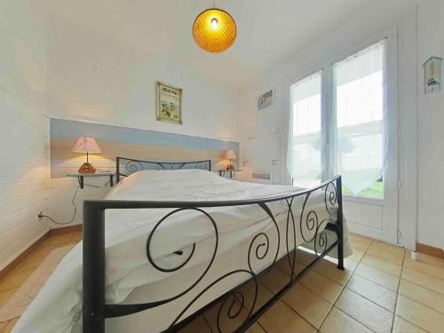 een slaapkamer met een bed in een kamer met ramen bij Maison 4 pièces près plage - Saint-Denis-d'Oléron, 6 couchages - FR-1-246A-309 in Saint-Denis-dʼOléron