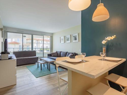 une cuisine et un salon avec une table et un canapé dans l'établissement Studio moderne en bord de mer avec accès piscine à Biarritz - FR-1-3-611, à Biarritz