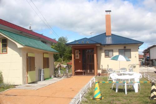 a house with a patio and a table with an umbrella at 静かな田舎の一軒家 ご家族友達観光大型スキー場近郊 in Mikage