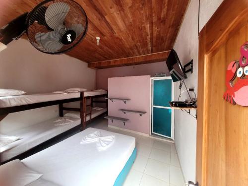 AcantiHotel Zona Libre Capurganá - Cerca a la playa y el muelle的客房设有两张双层床和风扇。