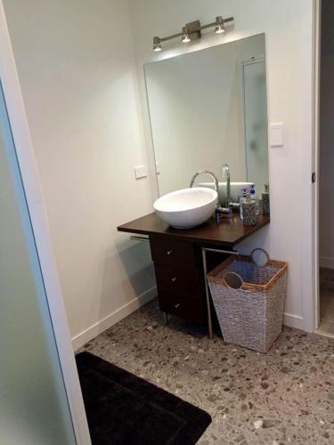 a bathroom with a sink and a large mirror at The Guest House in Tamahere