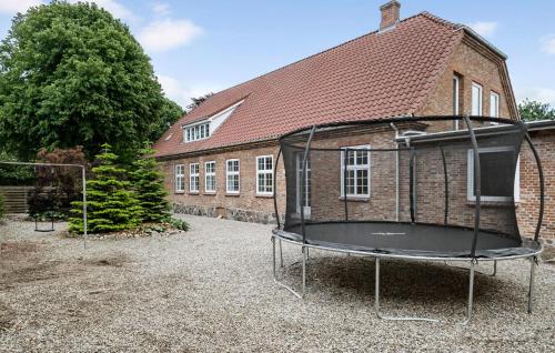 a building with a trampoline in front of a house at Amazing Home In Skærbæk With Kitchen in Skærbæk