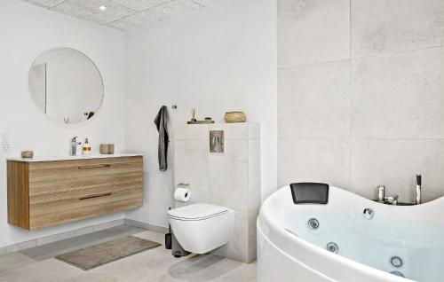 a bathroom with a tub and a toilet and a sink at Amazing Home In Skærbæk With Kitchen in Skærbæk