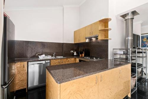 a kitchen with wooden cabinets and a counter top at Mowamba D5 in Thredbo