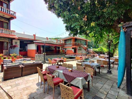 a patio with tables and chairs and a building at Lake View Resort in Pokhara