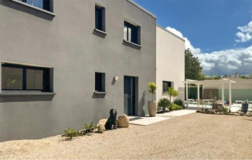 a house with a dog sitting in front of it at Modern Villa With Private Pool in Saint-Aignan-Grand-Lieu