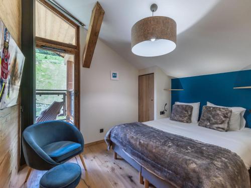 une chambre avec un lit et un mur bleu dans l'établissement Penthouse neuf avec balcon Sud, proche piste, cheminée, parking, WIFI - FR-1-563-155, à Courchevel