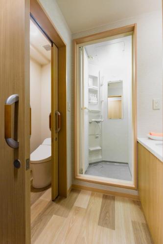 a bathroom with a toilet and a glass door at Yumoto Noboribetsu in Noboribetsu