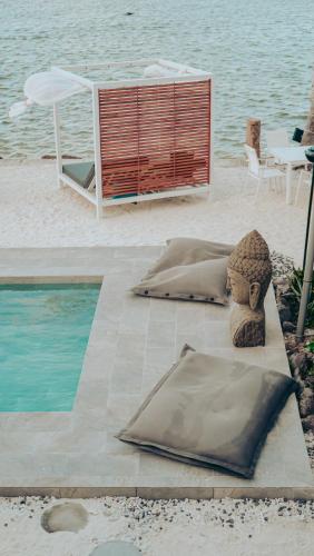 a sculpture of a person sitting next to a pool at Pension Irivai appartement PUATOU 1 chambre bord de mer in Uturoa