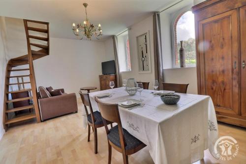 une salle à manger avec une table et un chiffon de table blanc dans l'établissement L'etang, à Mézières-sur-Couesnon