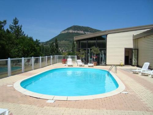 a large swimming pool on a brick patio at Tempo Hôtel in Millau