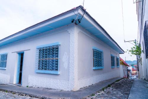 a white building with blue windows on a street at Casa Ramona in Flores