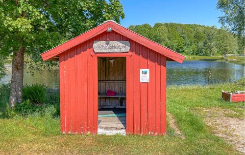 a red out house with a door in the grass at Stunning Apartment In Burseryd in Burseryd