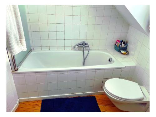 Un baño blanco con bañera y inodoro. en Chambre double dans maison lumineuse Saint Job Uccle, en Bruselas
