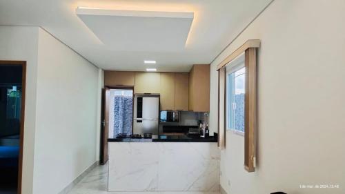 a living room with a kitchen with a counter top at Casa com piscina e hidromassagem praia Enseada. in Guarujá