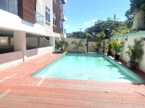 a swimming pool on the side of a building at LIGUANEA -ONE BEDROOM OASIS near US EMBASSY in Barbican