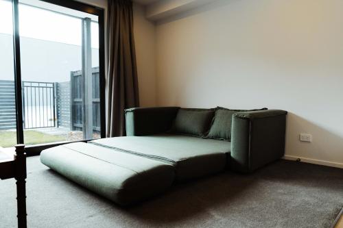 a couch in a room with a large window at New townhouse, 300m 4 minute walk Te Kaha One New Zealand Stadium, car park, 2 bed 2 bath in Christchurch