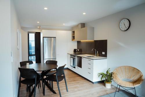 a kitchen and dining room with a table and chairs at New townhouse, 300m 4 minute walk Te Kaha One New Zealand Stadium, car park, 2 bed 2 bath in Christchurch