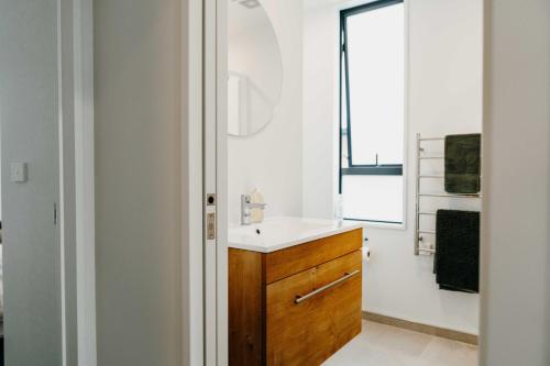 a bathroom with a sink and a mirror at New townhouse, 300m 4 minute walk Te Kaha One New Zealand Stadium, car park, 2 bed 2 bath in Christchurch