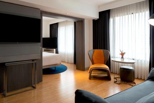 a hotel room with a bed and a television at Novotel Bangkok on Siam Square in Bangkok