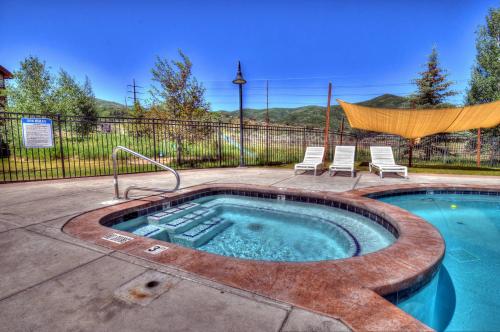 a pool with a hot tub with two chairs at Black Rock Ridge 14202 by Moose Management in Park City