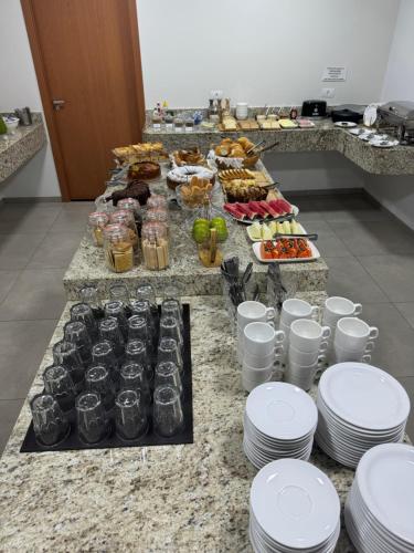 a buffet with plates and food on a table at Hotel 7 Quedas in Guaíra
