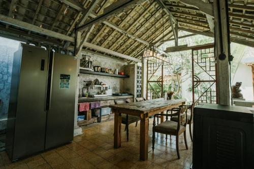 a kitchen with a table and a refrigerator at Dormitory at Semadi living in Sukawati