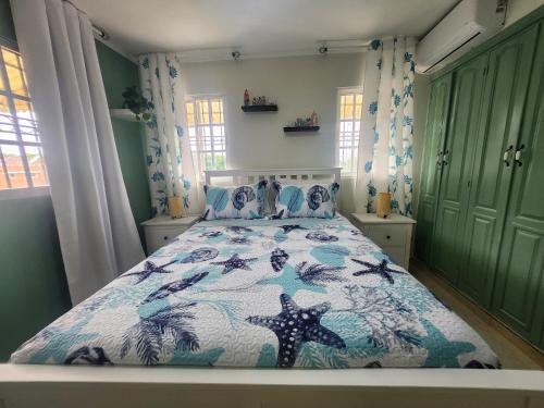a bedroom with a bed with a blue and white comforter at Penthouse Apartment with Bay and Mountain Views, Rooftop BBQ, AC, Fast WiFi, Near Saladilla Beach, Barahona in Santa Cruz de Barahona