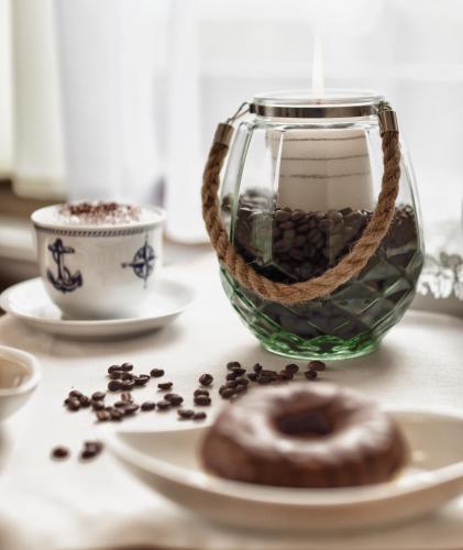 a table with a vase and a donut and a cup of coffee at Willa Kapitańska i Willa Marynarska in Łeba