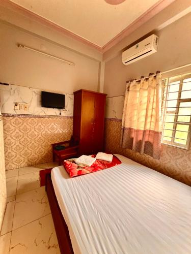 a small bedroom with a bed and a tv at Cao Nguyên Xanh in Bao Loc