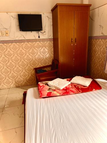a bedroom with a bed and a cabinet and a tv at Cao Nguyên Xanh in Bao Loc