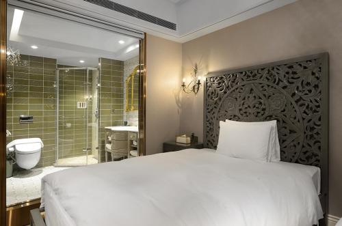 a bedroom with a bed and a bathroom with a shower at 格拉斯行館 Grasse Grace Manor 苗栗唯一SLH會員 in Nanzhuang