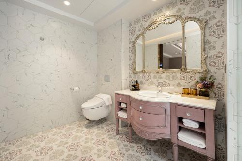 a bathroom with a sink and a mirror and a toilet at 格拉斯行館 Grasse Grace Manor 苗栗唯一SLH會員 in Nanzhuang