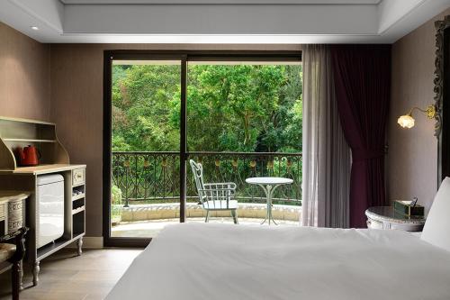 a hotel room with a bed and a large window at 格拉斯行館 Grasse Grace Manor 苗栗唯一SLH會員 in Nanzhuang