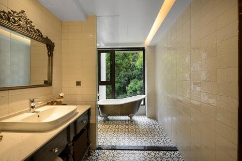 a bathroom with a tub and a sink and a window at 格拉斯行館 Grasse Grace Manor 苗栗唯一SLH會員 in Nanzhuang