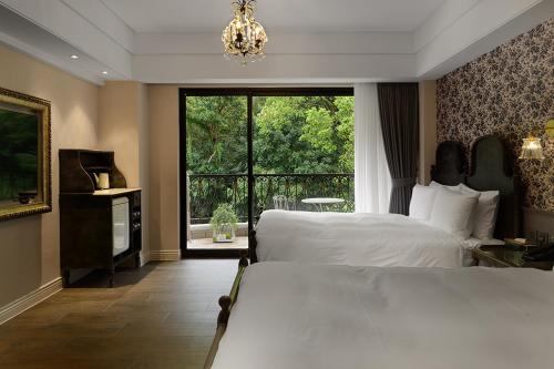a bedroom with two beds and a large window at 格拉斯行館 Grasse Grace Manor 苗栗唯一SLH會員 in Nanzhuang