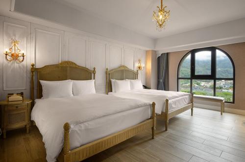 a large bedroom with two beds and a window at 格拉斯行館 Grasse Grace Manor 苗栗唯一SLH會員 in Nanzhuang