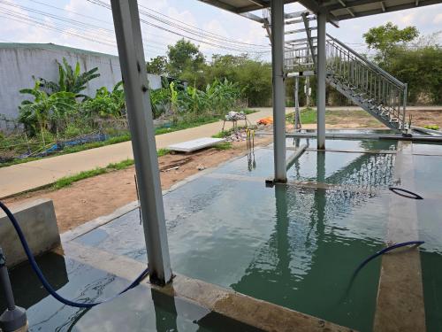 une piscine d'eau au-dessus d'une maison dans l'établissement Phu My studio - 72, à Phú Mỹ